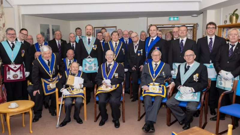 Members of the lodge sit in the homes day room in full regalia