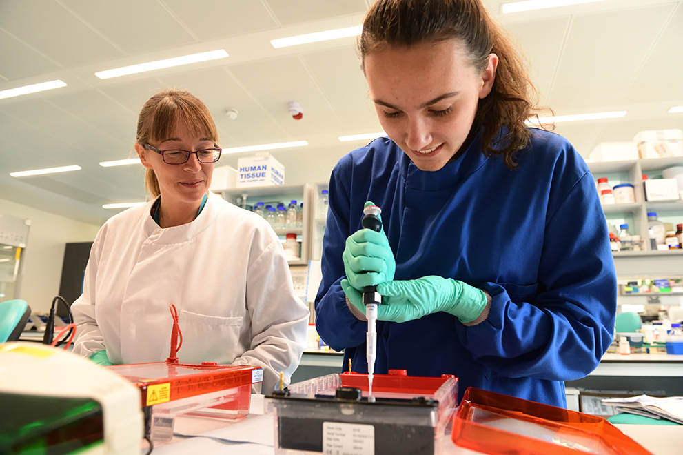 Two scientists, Dr Rachel Hurst and a student of University of East Anglia, conduct together research in a lab.