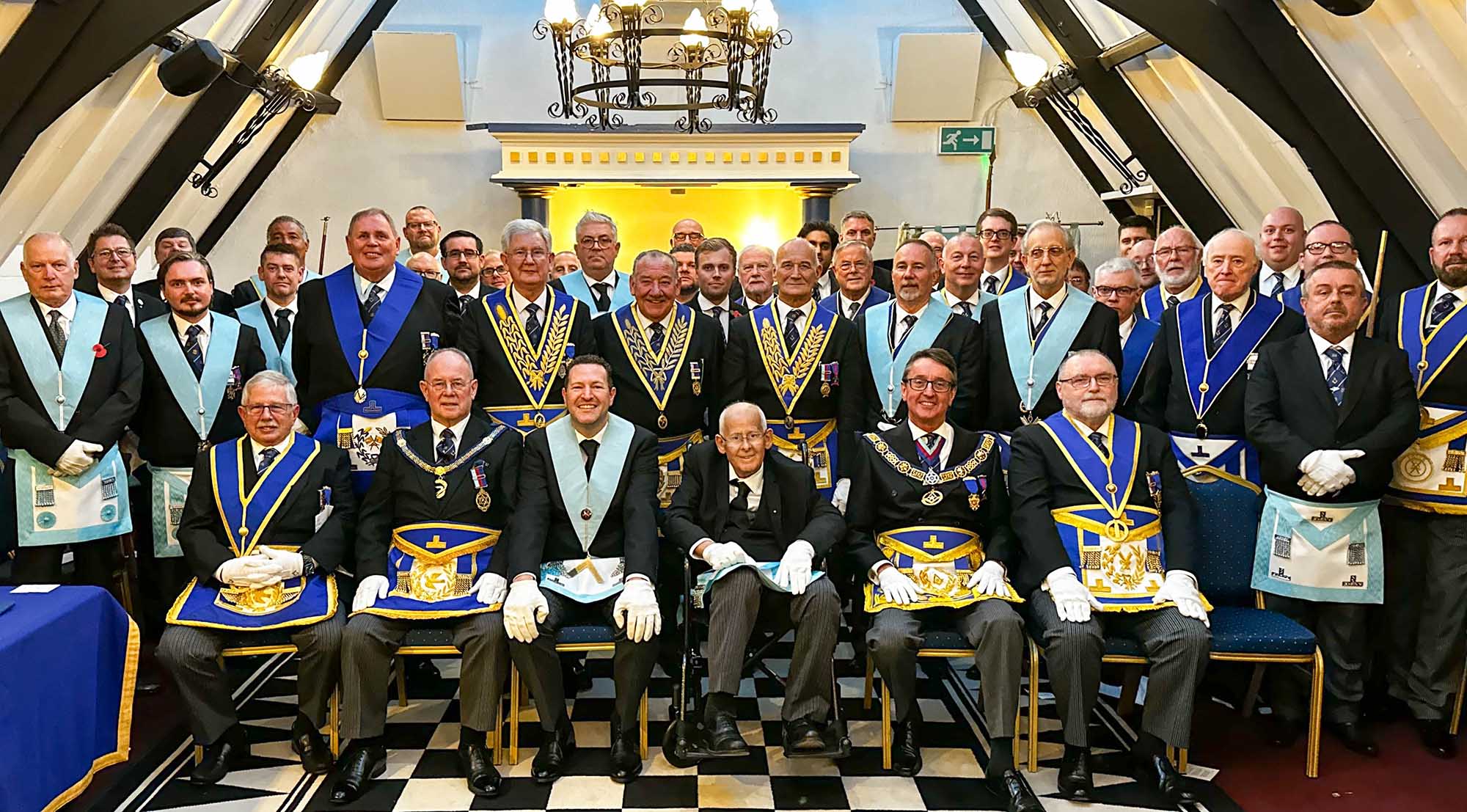 Charles is seated in the centre of a large group of freemasons wearing full regalia