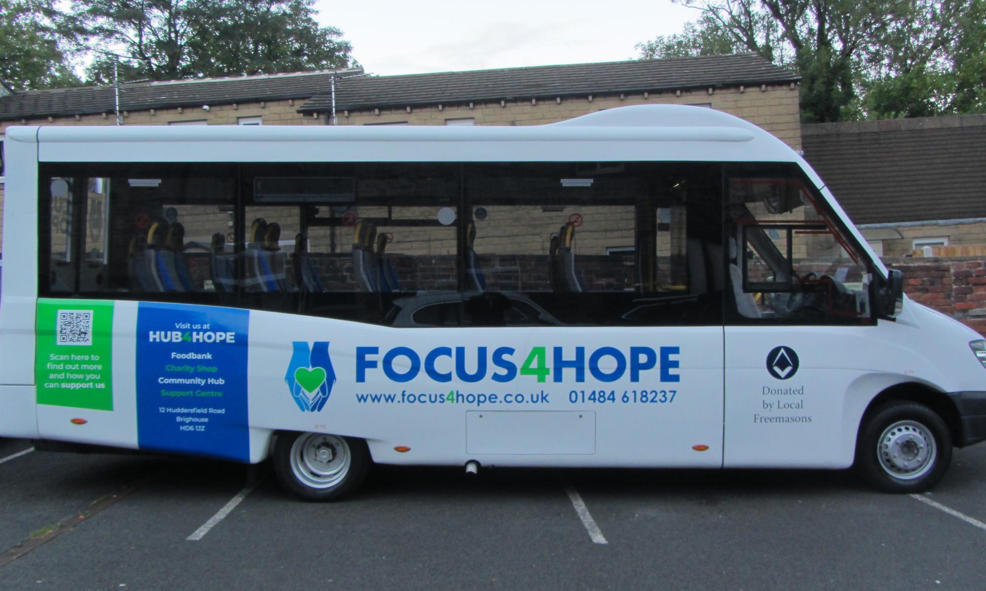 Focus4Hope's new 16-seat minibus, which with blue and green decals.