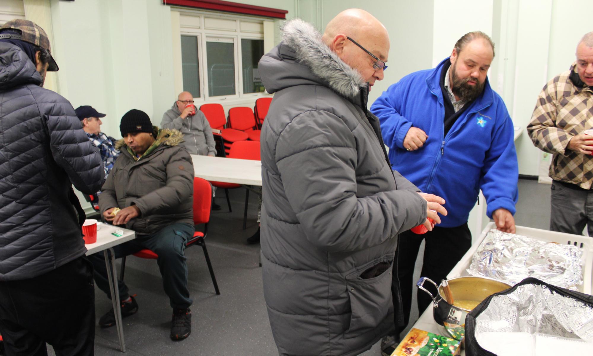 Darren Gregory (second right) and Ezra McGowan (right) hard at work dispensing soup and pies.