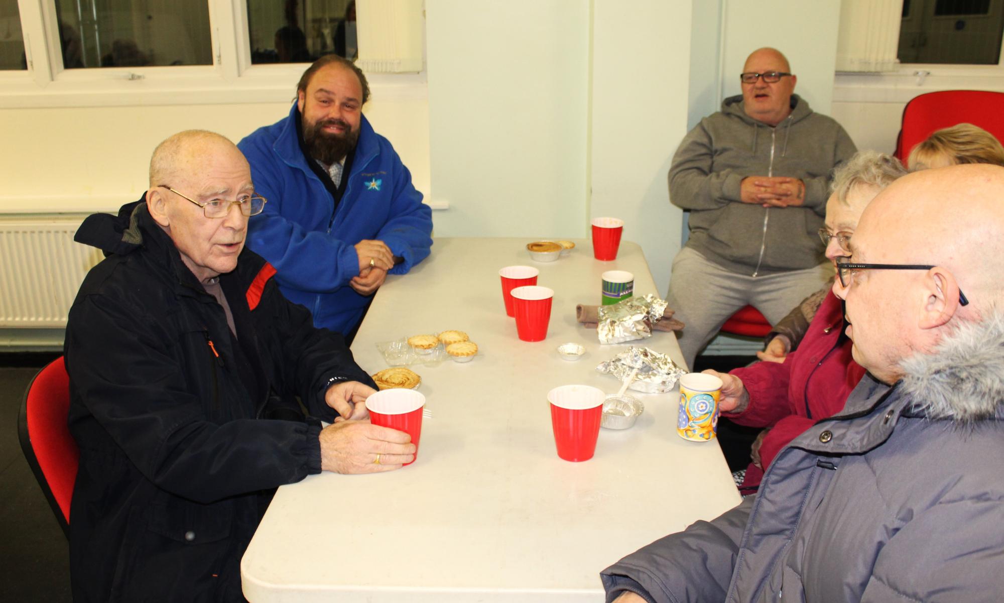 Ezra (second left) and Darren (right) chatting with locals at the Soup Kitchen.