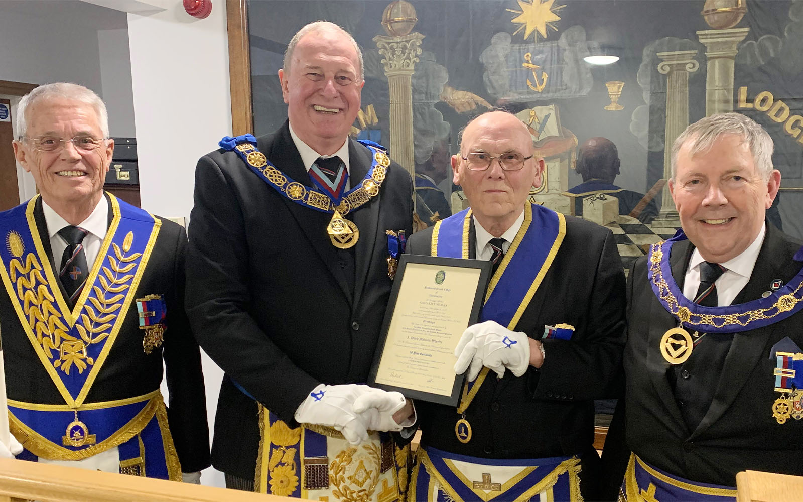 Gerald receives his 60-year certificate from Lincolnshire PGM Dave Wheeler, watched by Provincial DC Noel Fisher, left, and APGM Bruce Goodman.