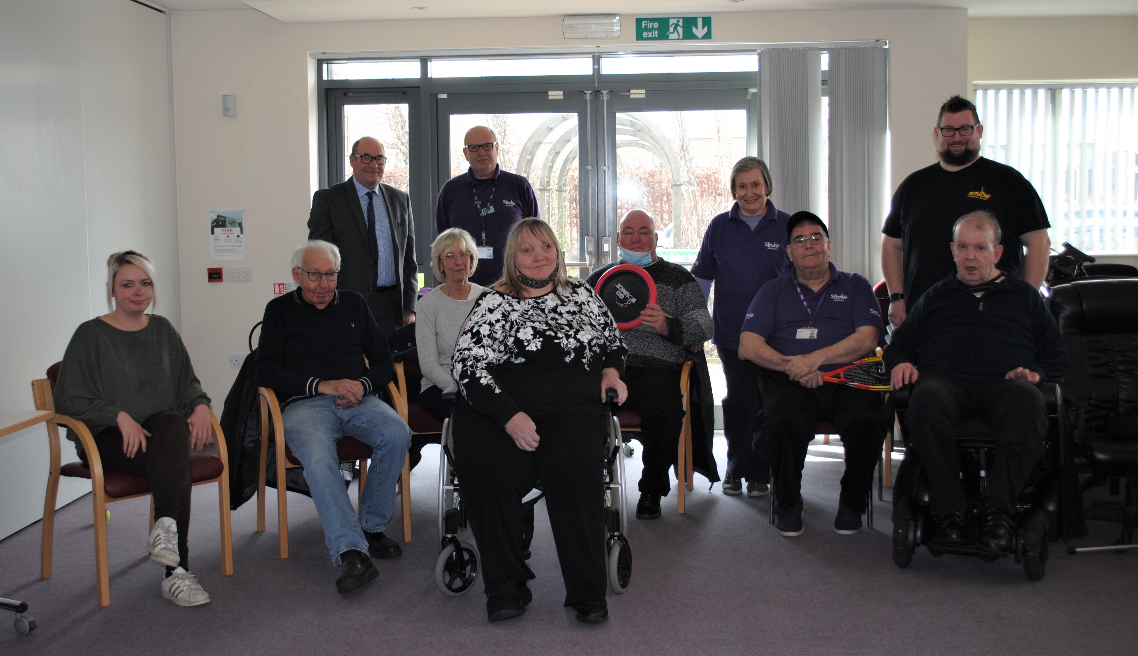 A group image of various people in the lobby of a care home.
