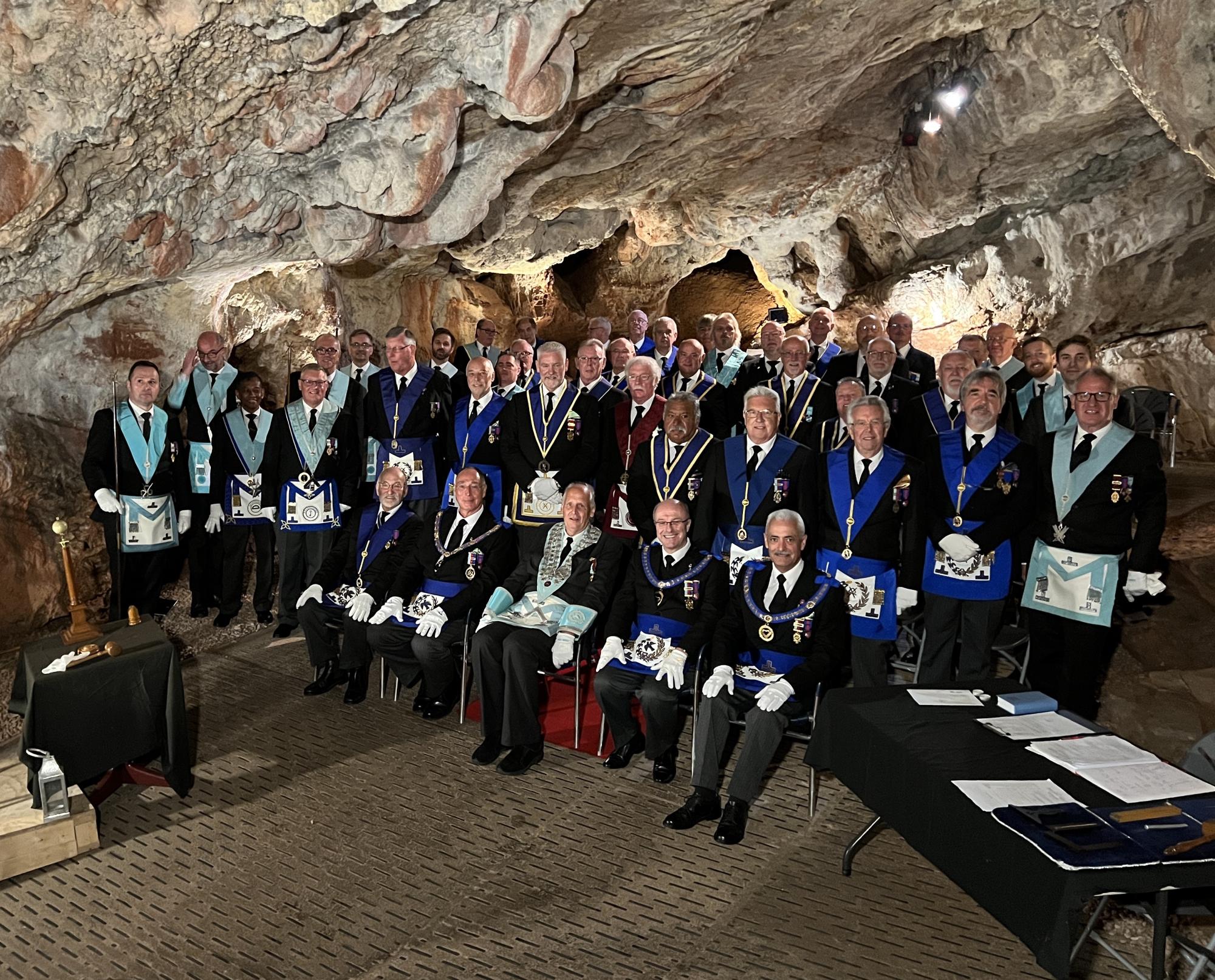 Worshipful Master of Miles Coverdale Lodge No. 5069, David Hopkins (seated centre) accompanied by three Assistant Provincial Grand Masters, officers and members of Miles Coverdale Lodge and guests at the 736th regular meeting underground in Kent's Cavern, Devon