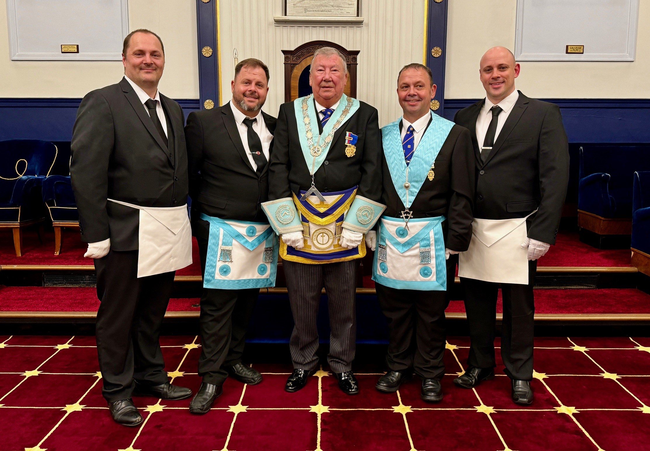 Four brothers in a masonic lodge wearing regalisa