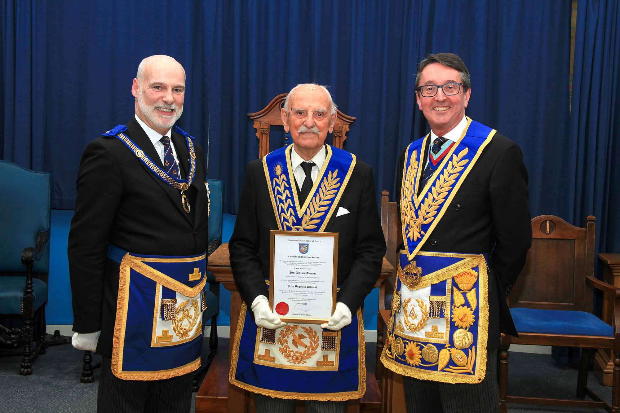 Rob Eels, Peter Bidmead, Paul Tarrant, stand in a row wearing full regalia