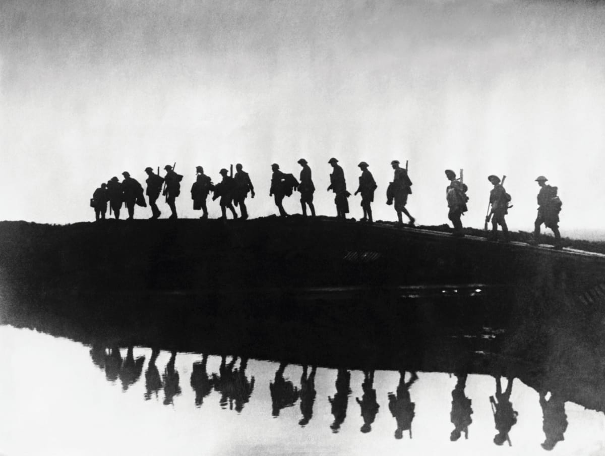 British troops from the East Yorkshire Regiment passing a shell crater, c.1917