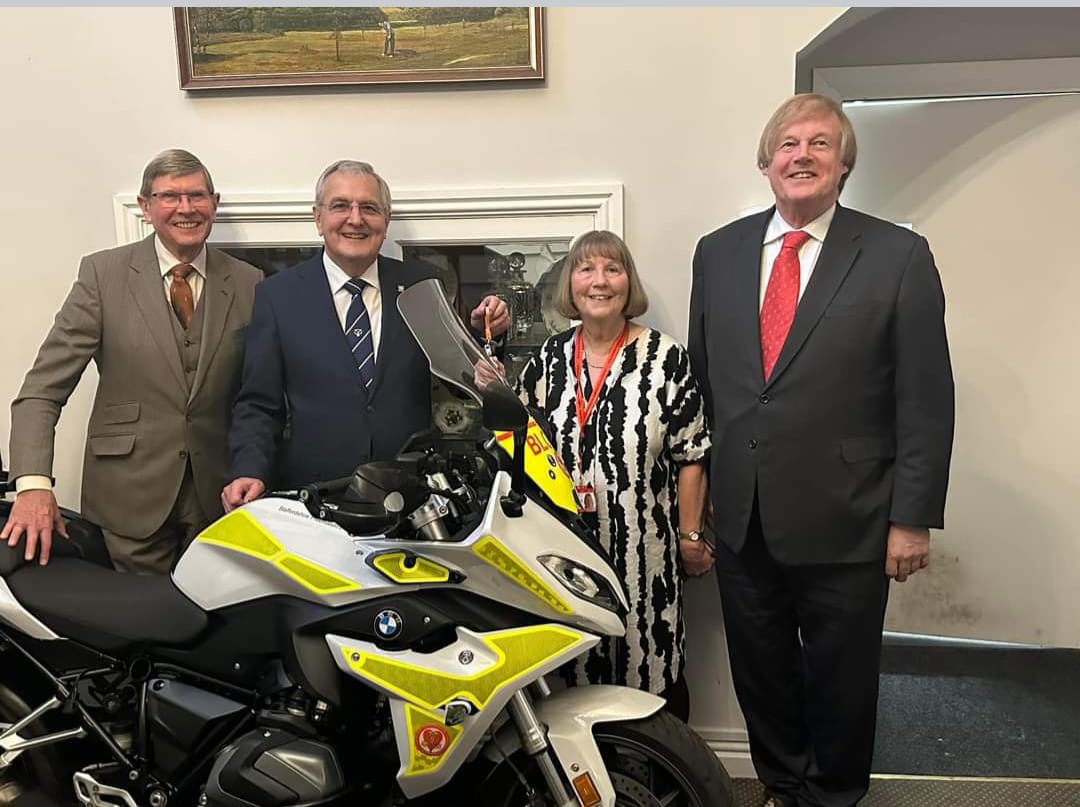 Staffordshire Freemasons and Deputy Grand Master Sir David Wootton standing with the donated Blood Bike