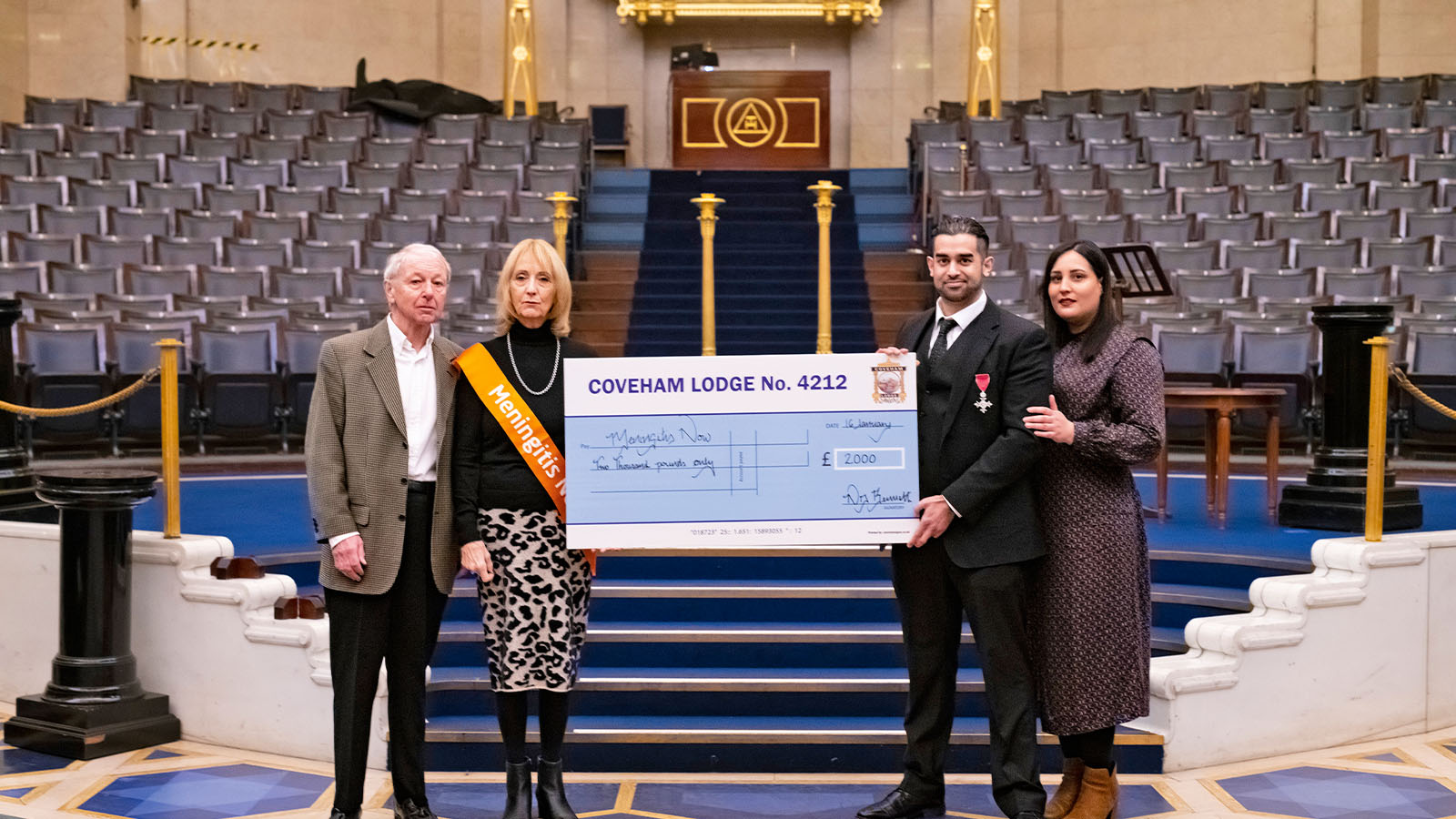 A group of people holding a cheque