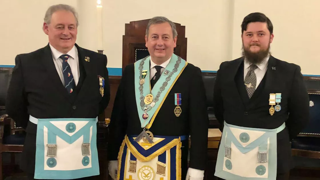 Three Freemasons in full regalia.