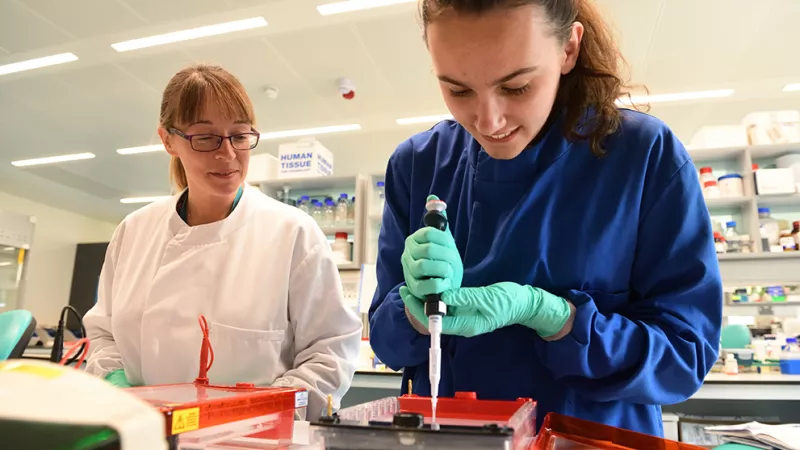 Two scientists, Dr Rachel Hurst and a student of University of East Anglia, conduct together research in a lab.