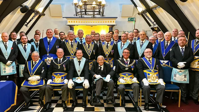 Charles is seated in the center of a large group of freemasons in full regalia
