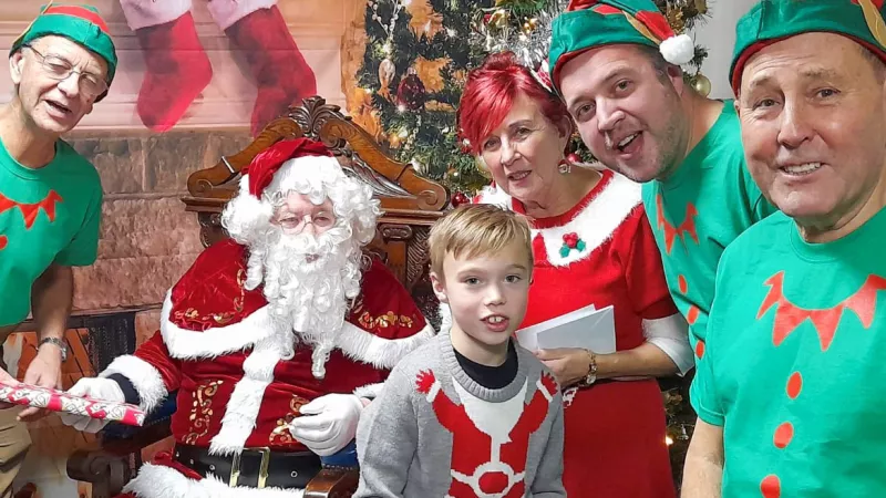 Elves L-R Clive Cheeseman, Dave Barton and Chris Bushell with John Lally as Santa and Sandra Lally as Mrs Claus