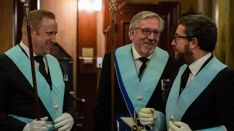 A trio of freemasons talking and laughing together