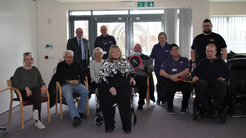 A group image of various people in the lobby of a care home.