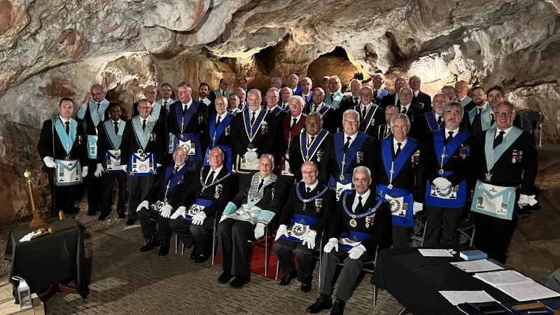 Worshipful Master of Miles Coverdale Lodge No. 5069, David Hopkins (seated centre) accompanied by three Assistant Provincial Grand Masters, officers and members of Miles Coverdale Lodge and guests at the 736th regular meeting underground in Kent's Cavern, Devon