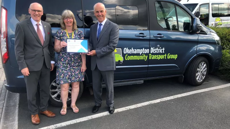 Freemasons Nicholas Ball and Anthony Eldred present a certificate for the donation of £15,000 to Sue Wonnacott, manager of the Okehampton & District Community Transport Group