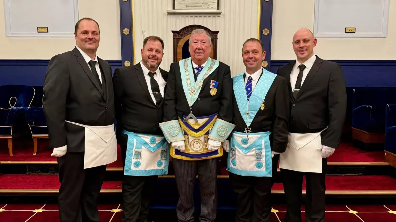 Four brothers in a masonic lodge wearing their regalia