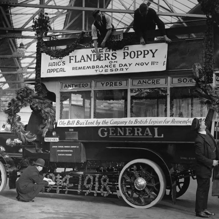 Workers decorate Old Bill, a WWI bus with garlands and wreaths for Poppy Day in honour of WWI Armistice. The symbol was adopted by Haig in 1921, as a founder of the Royal British Legion, c.1921