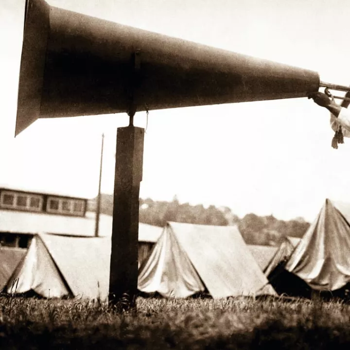 United States Naval Training Camp in Seattle, WA., a soldier amplifies the sound of his bugle by blowing into a giant megaphone c.1917